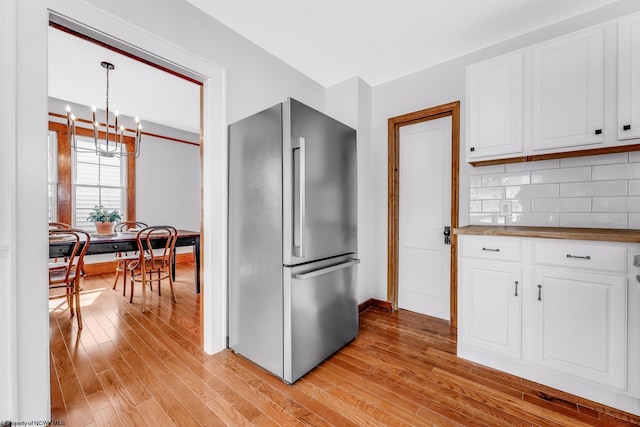 303 Saint Clair St, Clarksburg, WV 26301 - kitchen with freestanding refrigerator, a chandelier, light wood-style floors, and white cabinets