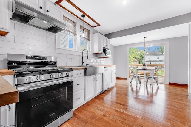 303 Saint Clair St, Clarksburg, WV 26301 - kitchen featuring appliances with stainless steel finishes, under cabinet range hood, a sink, a chandelier, and butcher block counters