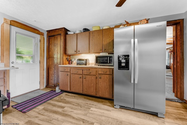 14318 N Preston Hwy, Bruceton Mills, WV 26525 - kitchen with stainless steel appliances, light wood-style floors, light countertops, and brown cabinets
