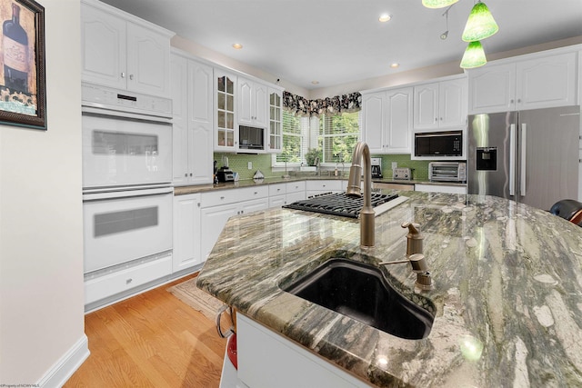 1300 Deer Run, Morgantown, WV 26508 - kitchen with double oven, decorative backsplash, stainless steel fridge with ice dispenser, light wood-style floors, and built in microwave