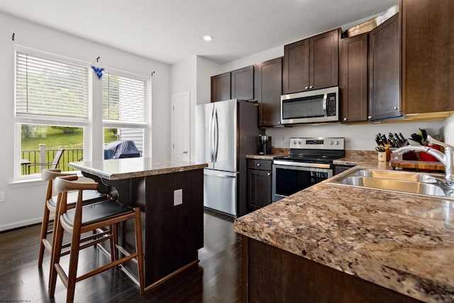 119 Inlet St, Morgantown, WV 26508 - kitchen featuring appliances with stainless steel finishes, a sink, a kitchen island, dark brown cabinets, and a kitchen breakfast bar