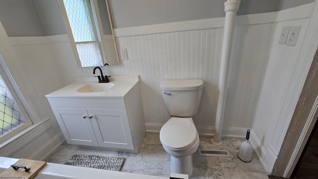 92 N High St, Philippi, WV 26416 - bathroom with marble look tiles, toilet, a wainscoted wall, and vanity