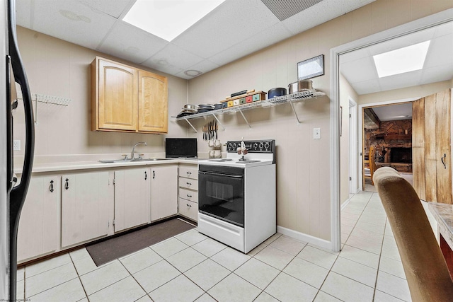 142 Vecchio Ln, Morgantown, WV 26508 - kitchen featuring electric range oven, light countertops, black refrigerator, light tile patterned floors, and wooden walls