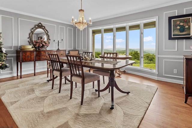 142 Vecchio Ln, Morgantown, WV 26508 - dining room featuring a decorative wall, a chandelier, healthy amount of natural light, crown molding, and light wood-type flooring