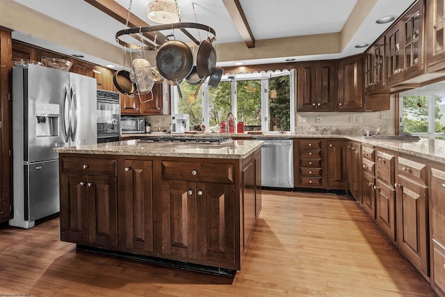 142 Vecchio Ln, Morgantown, WV 26508 - kitchen featuring appliances with stainless steel finishes, light wood-style flooring, beamed ceiling, a kitchen island, and light stone countertops