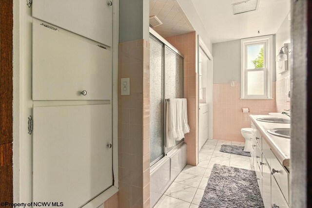 159 E Main St, Clarksburg, WV 26301 - full bathroom with tile walls, double vanity, marble finish floors, a wainscoted wall, and combined bath / shower with glass door
