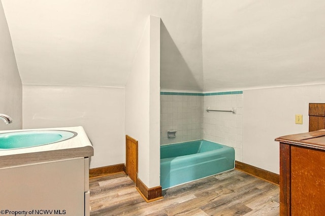 159 E Main St, Clarksburg, WV 26301 - full bath with vanity, wood finished floors, a bath, and vaulted ceiling