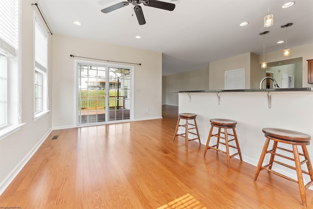 453 Blackberry Ridge Dr, Morgantown, WV 26508 - kitchen with a breakfast bar area, a ceiling fan, dark countertops, light wood-style floors, and recessed lighting