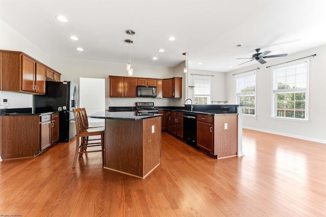 453 Blackberry Ridge Dr, Morgantown, WV 26508 - kitchen with black appliances, dark countertops, light wood-type flooring, a peninsula, and recessed lighting