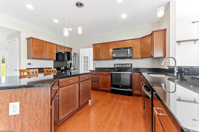 453 Blackberry Ridge Dr, Morgantown, WV 26508 - kitchen featuring black appliances, light wood-style flooring, a center island, pendant lighting, and brown cabinetry