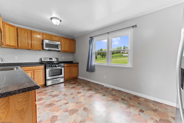 48 Skyline Dr, Morgantown, WV 26508 - kitchen with appliances with stainless steel finishes, stone finish flooring, dark countertops, and brown cabinetry