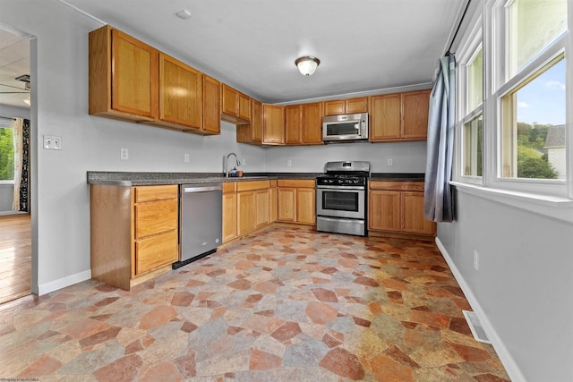 48 Skyline Dr, Morgantown, WV 26508 - kitchen featuring stainless steel appliances, light stone finish floors, dark countertops, and brown cabinets