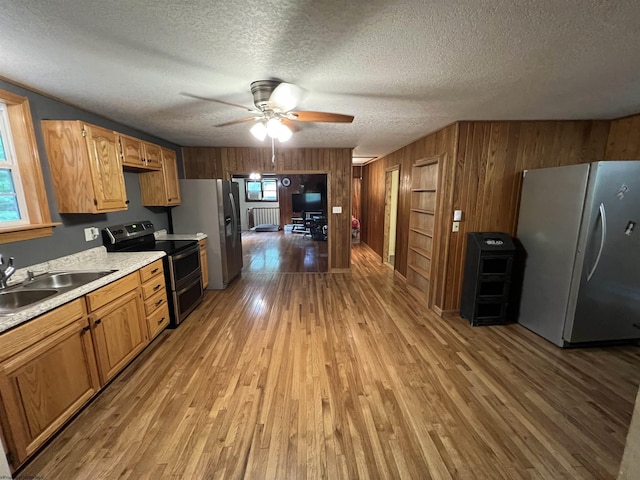60 Saras Way, Beverly, WV 26253 - kitchen with stainless steel appliances, wood walls, light countertops, ceiling fan, and light wood-type flooring