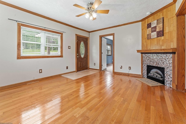 2228 Dinnerbell Five Forks Rd, Farmington, PA 15437 - entryway with light wood-style flooring, ceiling fan, ornamental molding, a tiled fireplace, and a textured ceiling