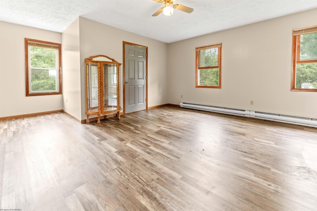 2228 Dinnerbell Five Forks Rd, Farmington, PA 15437 - unfurnished room with a baseboard heating unit, light wood finished floors, ceiling fan, plenty of natural light, and a textured ceiling