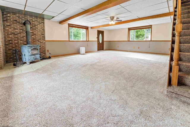 2228 Dinnerbell Five Forks Rd, Farmington, PA 15437 - unfurnished living room with a wood stove, carpet floors, stairway, a paneled ceiling, and a ceiling fan
