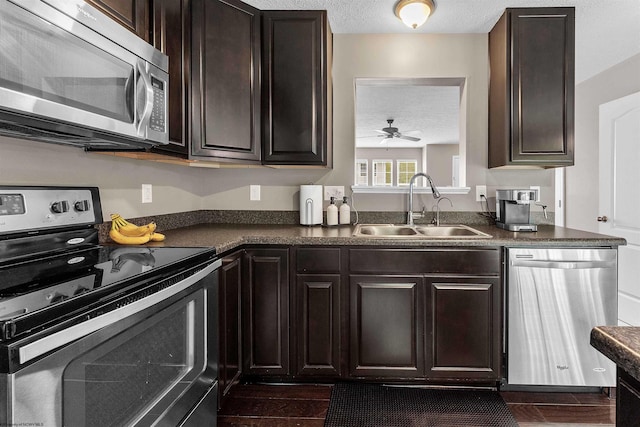 126 Auburn Dr, Morgantown, WV 26501 - kitchen with appliances with stainless steel finishes, dark countertops, a textured ceiling, a ceiling fan, and dark brown cabinets