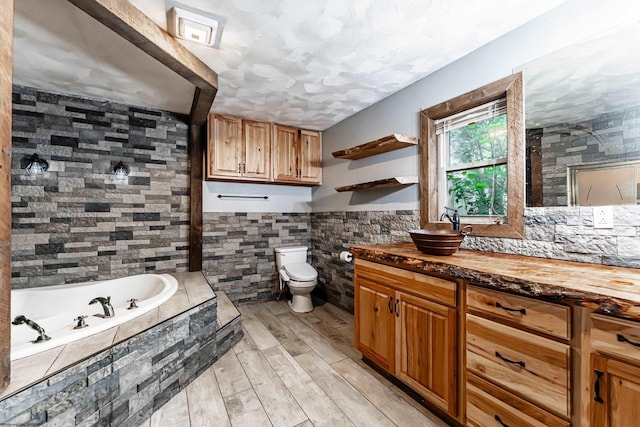 482 Buckeye Rd, Core, WV 26541 - bathroom featuring a garden tub, vanity, tile walls, wood finished floors, and a wainscoted wall