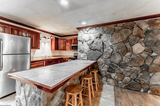482 Buckeye Rd, Core, WV 26541 - kitchen with appliances with stainless steel finishes, ornamental molding, a peninsula, a breakfast bar, and tile counters