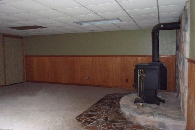 208 Parkview Cir, Kingwood, WV 26537 - below grade area featuring a wood stove, wainscoting, wooden walls, and a drop ceiling