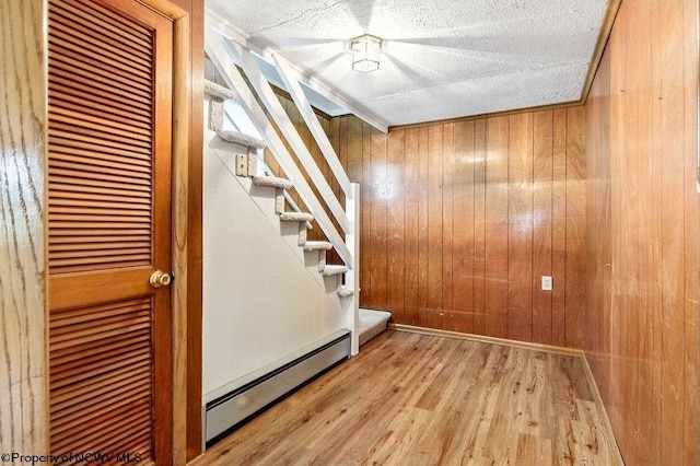 2300 Pride Ave, Clarksburg, WV 26301 - stairs with baseboard heating, wood walls, wood finished floors, and a textured ceiling