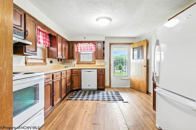 2300 Pride Ave, Clarksburg, WV 26301 - kitchen with white appliances, under cabinet range hood, light wood-style flooring, light countertops, and a textured ceiling