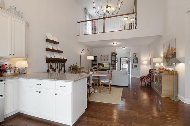 211 Berkshire Cir, Bridgeport, WV 26330 - kitchen featuring a peninsula, white cabinets, a chandelier, dark wood-type flooring, and a towering ceiling
