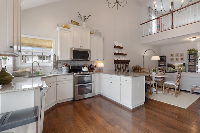 211 Berkshire Cir, Bridgeport, WV 26330 - kitchen with appliances with stainless steel finishes, a peninsula, a towering ceiling, white cabinets, and backsplash