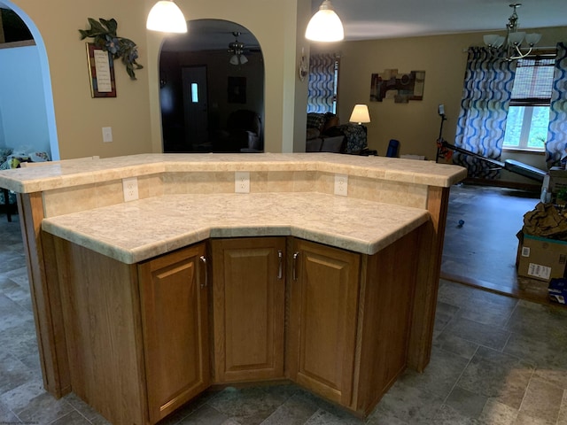 52 Ladder Dr, Mount Clare, WV 26408 - kitchen with arched walkways, ceiling fan, stone finish flooring, light countertops, and a kitchen island