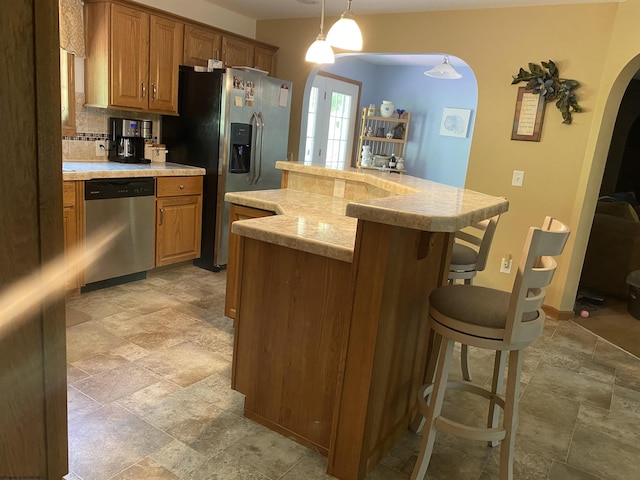 52 Ladder Dr, Mount Clare, WV 26408 - kitchen featuring stainless steel appliances, arched walkways, light stone finish floors, light countertops, and a kitchen bar