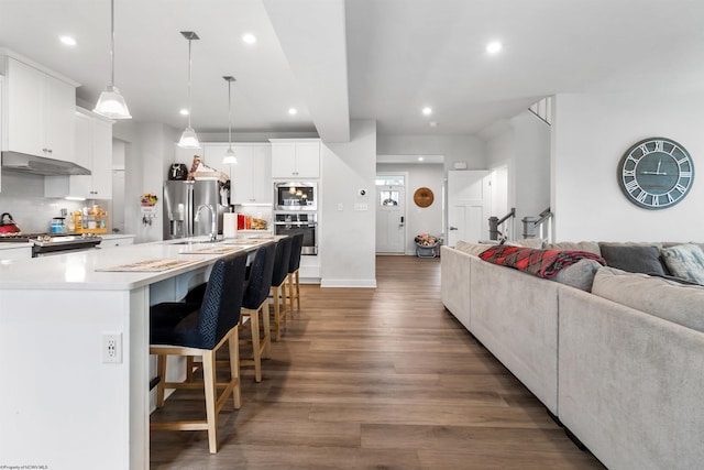 204 Falling Water Ln, Morgantown, WV 26508 - kitchen featuring open floor plan, stainless steel appliances, under cabinet range hood, wood finished floors, and a kitchen bar