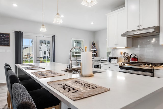 204 Falling Water Ln, Morgantown, WV 26508 - kitchen featuring under cabinet range hood, stainless steel range with gas stovetop, white cabinetry, backsplash, and light countertops