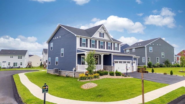 204 Falling Water Ln, Morgantown, WV 26508 - craftsman-style house with covered porch, asphalt driveway, a front lawn, and a garage