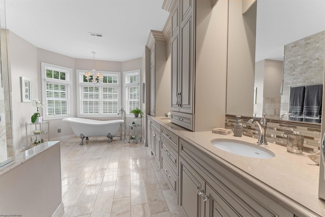 1009 Summit Dr, Morgantown, WV 26508 - bathroom featuring double vanity, a soaking tub, a chandelier, and decorative backsplash