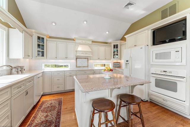 1348 Anderson Ave, Morgantown, WV 26505 - kitchen with white appliances, vaulted ceiling, backsplash, a center island, and light wood-style flooring