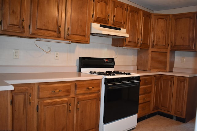 132 Racine St, Morgantown, WV 26505 - kitchen with gas stove, under cabinet range hood, brown cabinetry, and light countertops