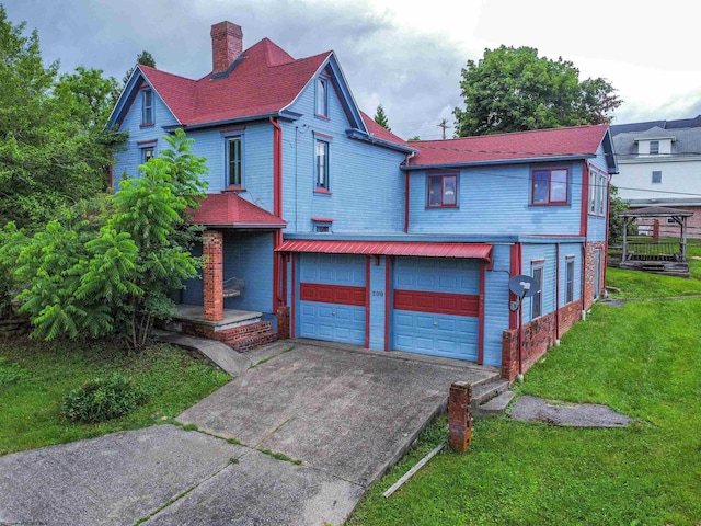 200 Webster Ave, Morgantown, WV 26501 - victorian home featuring concrete driveway, a chimney, a front yard, a garage, and brick siding