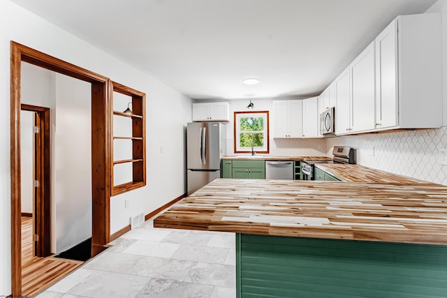 552 White Ave, Morgantown, WV 26501 - kitchen with appliances with stainless steel finishes, wooden counters, decorative backsplash, white cabinetry, and a peninsula