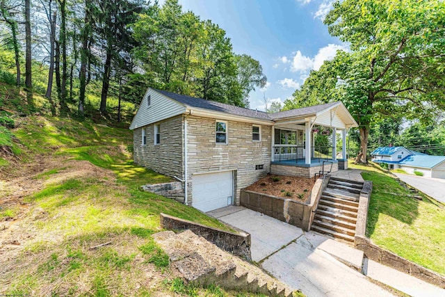 552 White Ave, Morgantown, WV 26501 - view of home's exterior featuring stone siding, concrete driveway, a porch, a garage, and a yard
