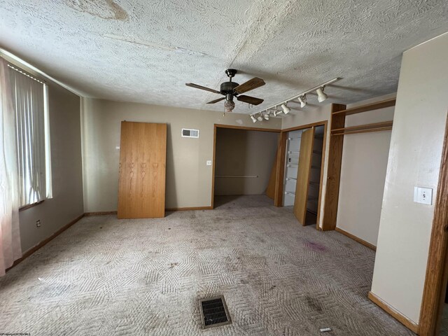 113 Buckhannon Ave, Clarksburg, WV 26301 - unfurnished bedroom featuring carpet, two closets, ceiling fan, rail lighting, and a textured ceiling