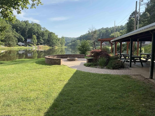 1998 Lake Floyd Cir, Bristol, WV 26426 - view of grassy yard featuring an outdoor fire pit, a water view, a patio, and a view of trees