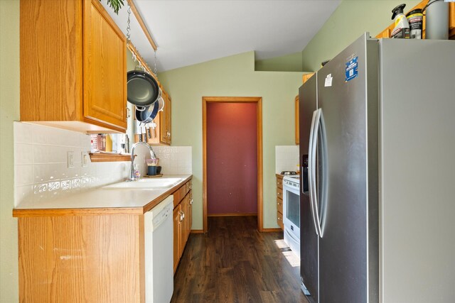 kitchen with vaulted ceiling, sink, decorative backsplash, dark wood-type flooring, and white appliances