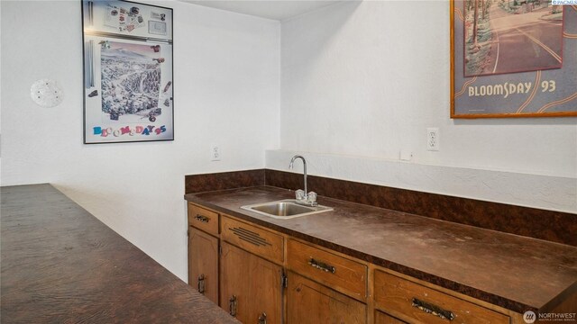 863 S Meadowlark Ln, Othello, WA 99344 - kitchen featuring a sink, dark countertops, and brown cabinets