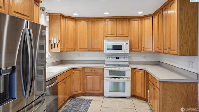 863 S Meadowlark Ln, Othello, WA 99344 - kitchen with appliances with stainless steel finishes, a sink, light tile patterned flooring, brown cabinetry, and recessed lighting
