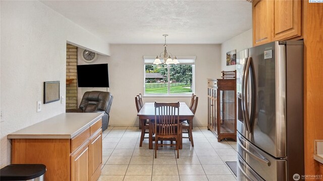 863 S Meadowlark Ln, Othello, WA 99344 - dining area with light tile patterned floors, a chandelier, and a textured ceiling