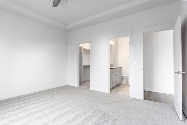 8509 Ashen Dr, Pasco, WA 99301 - unfurnished bedroom with light colored carpet, a walk in closet, ensuite bath, a closet, and ceiling fan