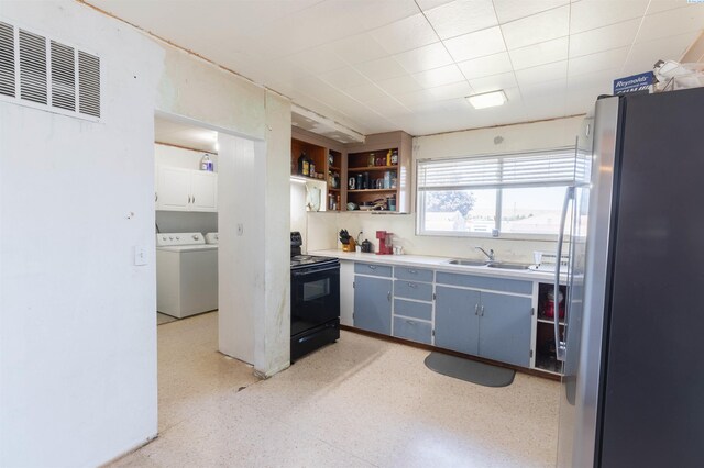 208 E 2nd, La Crosse, WA 99143 - kitchen featuring freestanding refrigerator, black range with electric cooktop, washer and clothes dryer, open shelves, and light countertops