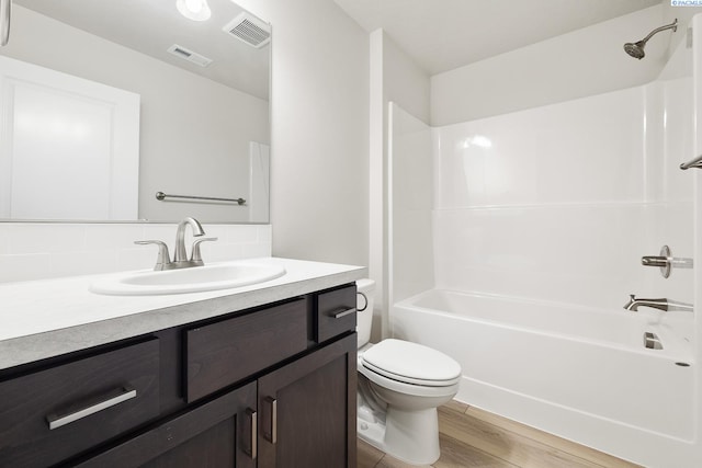 full bathroom with vanity, wood-type flooring,  shower combination, and toilet