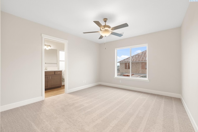 unfurnished bedroom with ceiling fan, light colored carpet, and ensuite bathroom