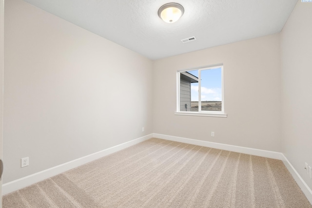 empty room with a textured ceiling and carpet